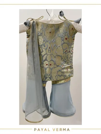 A closer look at the craftsmanship of our traditional wear. This custom Banarasi gharara set in powder blue and gold showcases intricate weaving and is paired with a delicate organza dupatta, perfect for weddings and pujas.
