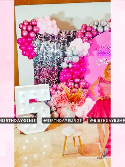 A detail shot of the Barbie party, focusing on the light-up number '5' and the elegant floral arrangement.
