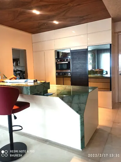 The kitchen island also serves as a breakfast counter, complete with a stylish bar stool. This open-concept design seamlessly integrates the kitchen with the rest of the living area.