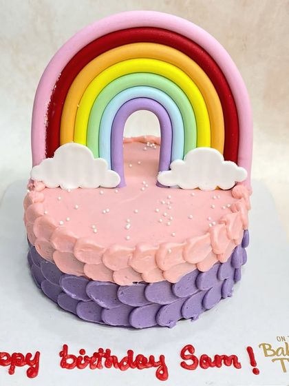 Taste the rainbow! This cute cake features a fondant rainbow topper and a colorful petal-piping effect on the side.