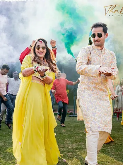 We love creating high energy moments. Here, the bride and groom make a grand entry at their Haldi celebration, dancing through clouds of vibrant, non toxic color smoke for a truly cinematic shot.