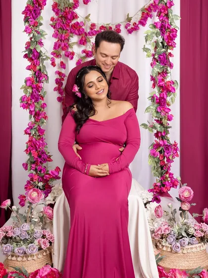 A sweet moment of the father-to-be embracing his partner from behind, both sharing a happy and relaxed moment.