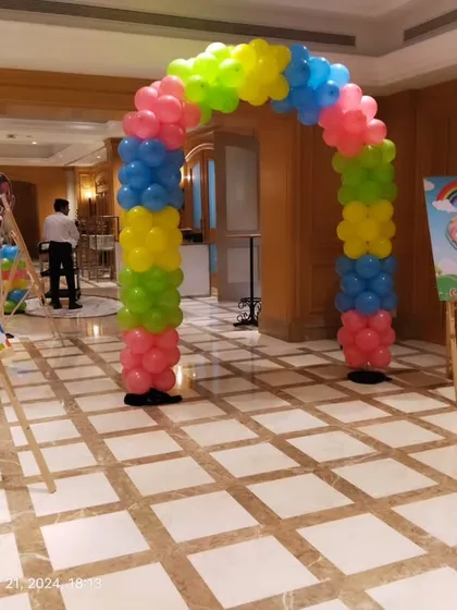 The welcome area for the Cocomelon party, with two custom signs on easels and a colorful balloon arch.