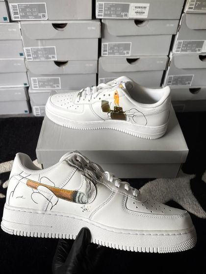 The other shoe in the pair, featuring a hand holding a lit joint that forms the swoosh.