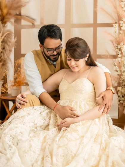 A sweet shot of a couple looking down at the baby bump together, a moment full of shared anticipation.