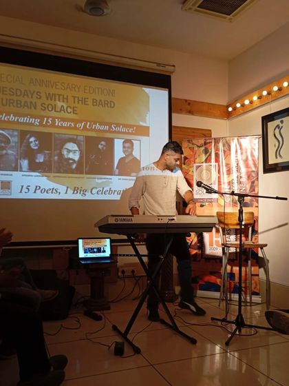 Another shot of our poet-musician, showcasing the full setup with the keyboard and microphone. We provide all the necessary equipment for artists to bring their vision to life.