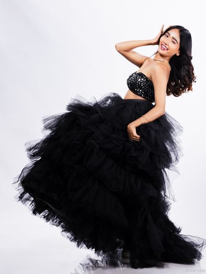 A playful and joyful shot of the model in the black tulle gown, winking at the camera. Capturing personality is key for a standout model portfolio.