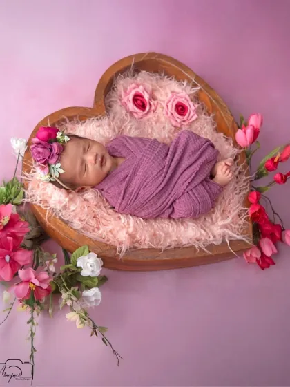 Another angle of the heart-shaped bowl setup, showing the baby peacefully sleeping. A perfect image for a birth announcement.