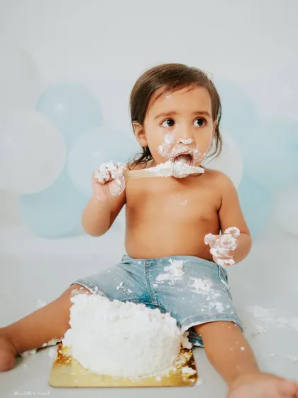Cake smash sessions are just as fun for boys. This little guy is digging into his first birthday cake with gusto during a simple and classic blue and white themed shoot in my Faridabad studio.