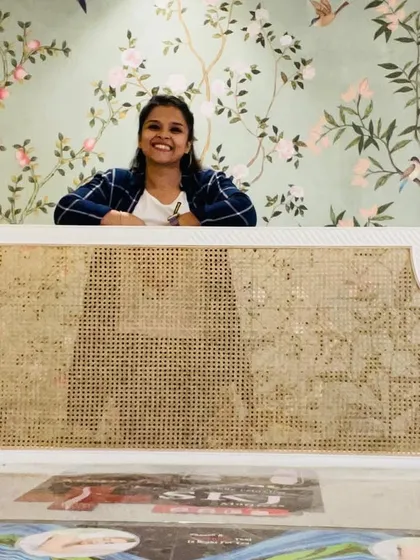 Me with a finished headboard, set against a beautiful floral mural I designed. It shows how my work can be part of a complete, harmonious interior concept.