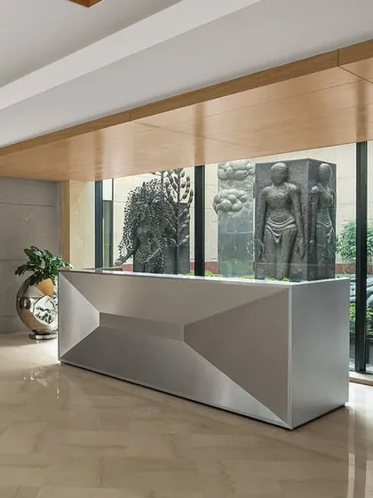 The reception desk, a striking parametric form, is positioned to offer a direct view of the central courtyard, immediately connecting the interior to the building's core feature.