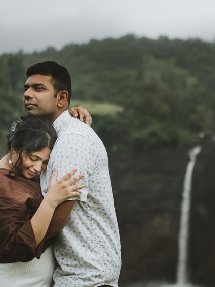 An intimate embrace with a beautiful waterfall in the background, this photo captures a quiet moment of connection.