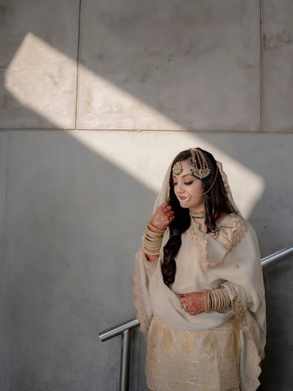 A solo portrait of Lubna, with a dramatic shadow falling across the frame, creating a moody and artistic image.