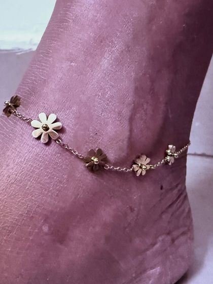 A close-up shot of a delicate flower anklet from Palmonas, showcasing a beautiful piece of demi-fine jewelry perfect for gifting.