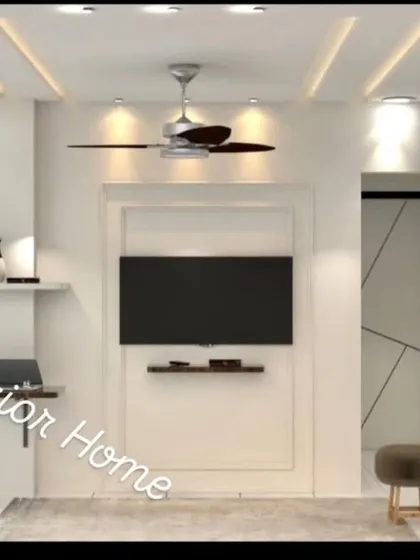 A bright and modern bedroom with a minimalist TV wall and a space-saving foldable study table. The white wardrobes with geometric lines add a subtle design element.