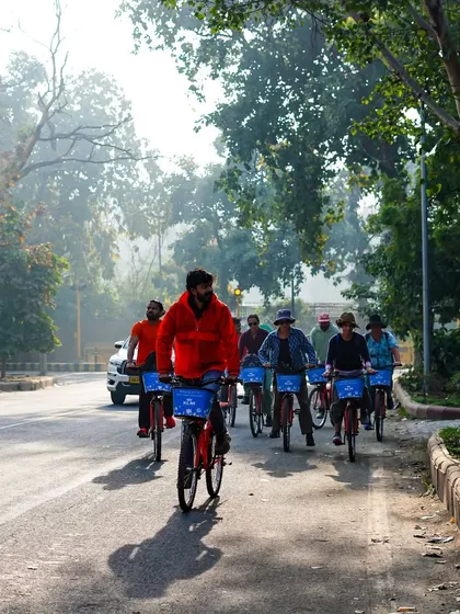 A group of riders enjoys the cool, misty morning air on a tree-lined street. These green avenues provide a beautiful and refreshing environment for our tours.