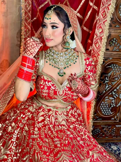 A close-up portrait. The green bindi and jewelry add a beautiful contrast to the red outfit.