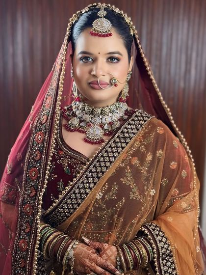 A full portrait of the bride. The makeup is bold enough to match the richness of the velvet, with a defined eye and lip.