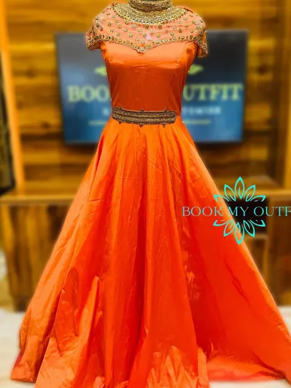 Make a bold statement in this vibrant orange ball gown. The intricate, high-neck beadwork and belted waist create a regal silhouette, making it an ideal rental for sangeets, weddings, or formal gatherings.