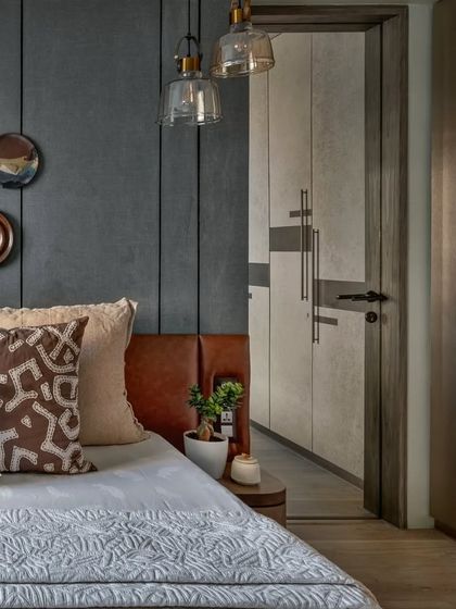 This angle shows the walk-in wardrobe entrance next to the bed. The consistent use of materials and textures creates a seamless flow between the different areas of the master suite.