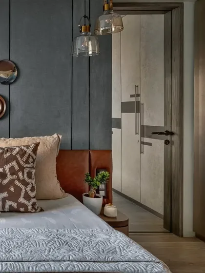 This angle shows the walk-in wardrobe entrance next to the bed. The consistent use of materials and textures creates a seamless flow between the different areas of the master suite.