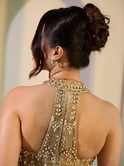 A detailed shot of the back of the romantic updo. You can see the soft twists and folds of the hair, creating a style that looks intricate yet effortless.
