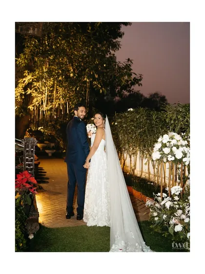A quiet moment together after the ceremony. The bride looks back, her long veil trailing behind, as they begin their walk into forever.