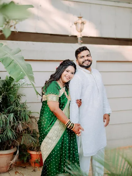 A happy couple portrait. The bride's half-up hairstyle with loose curls is a modern touch to her otherwise traditional look, perfect for a pre-wedding or engagement function.