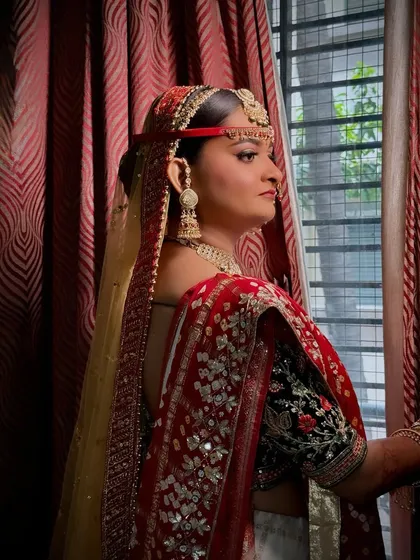 My Gujarati bride in red, looking like pure royalty. This side profile highlights the intricate hair bun and the perfectly draped dupatta.