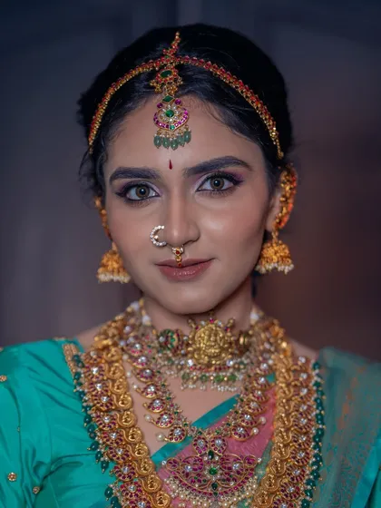 The beauty is in the details. This close-up shows our intricate temple jewellery, including the choker, layered haram, and matha patti, all available to create your perfect bridal look.