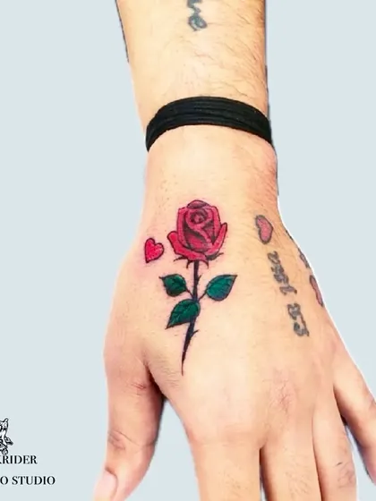A small red rose on the hand, a simple yet powerful statement. We can scale classic designs to fit any placement.