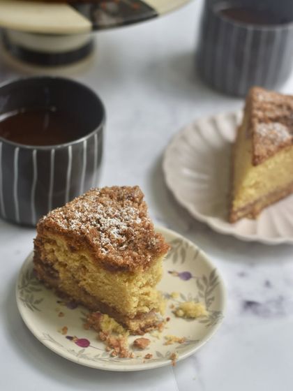 A cozy scene with our Plum & Almond Crumble Cake, a popular weekend special that we bring back by popular demand. It's the perfect companion for your afternoon chai or coffee.