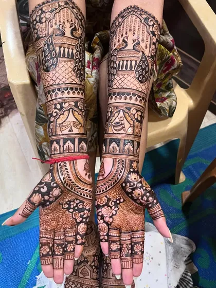 A close-up of the hands from the same bridal session. The intricate peacock and floral patterns are beautifully executed.