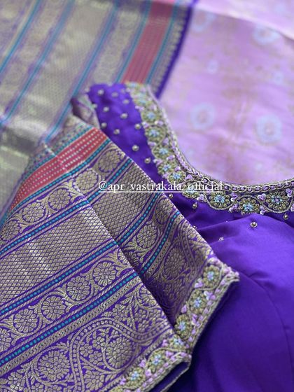A purple blouse with a gold brocade border on the sleeves.