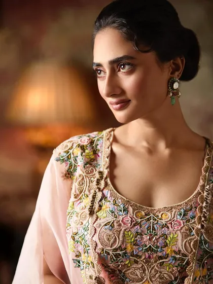 A close-up on the exquisite multi-colored floral embroidery of this cape set, showing the artistry and detail that I look for in my curated pieces.