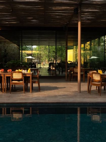 The Pavilion dining area set for guests, overlooking the infinity pool and the forest beyond.