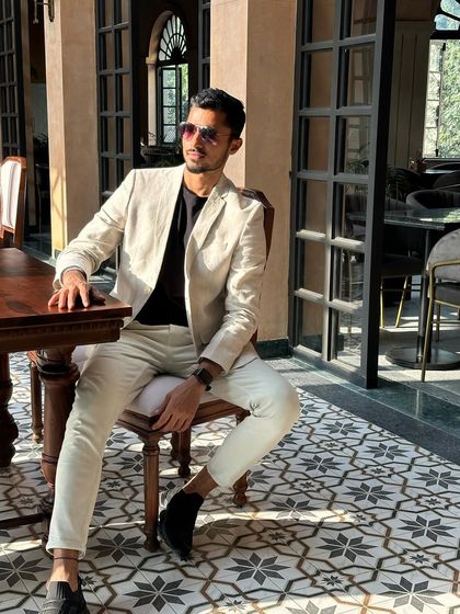 A relaxed yet sophisticated pose in a light-colored suit, perfect for a cafe or lifestyle shoot.