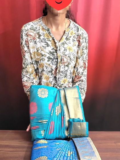 A happy student displaying the sarees she learned to pre-pleat and fold in my class.
