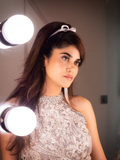 Reflecting on the glam. A beautiful shot of Aaditi Pohankar by the vanity lights, highlighting the flawless base and the intricate, shimmering details of her makeup.