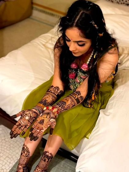 Another angle of the bride, looking down at her beautifully decorated hands and feet.