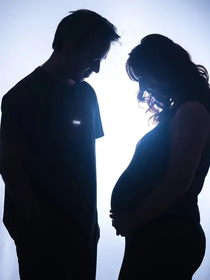 A silhouette is a powerful way to tell a story. In this studio maternity portrait, the focus is on the beautiful shape of the baby bump and the quiet connection between the expecting parents, creating a truly artistic and emotional image.