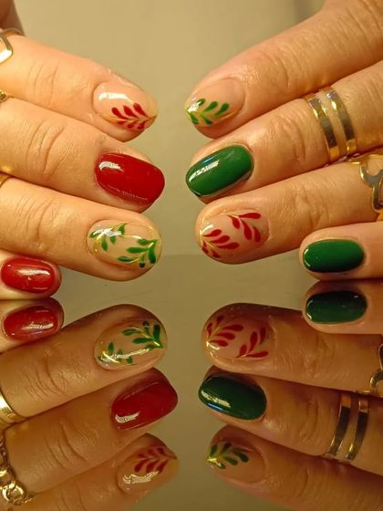 A festive holiday design with red and green nails and hand-painted holly leaf accents.
