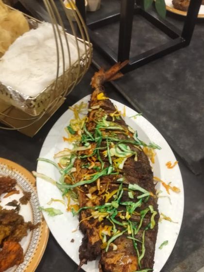 A beautifully presented whole fried fish, garnished and ready to be the star of the table.