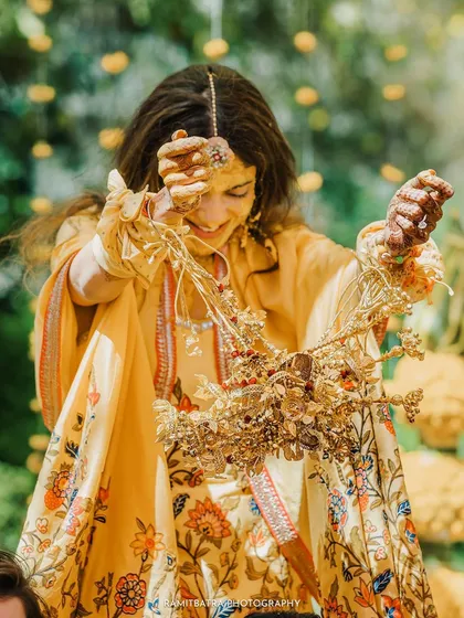 The bride playfully shakes the Kaleerey over her friends' heads, a fun tradition to see who will be the next to get married.