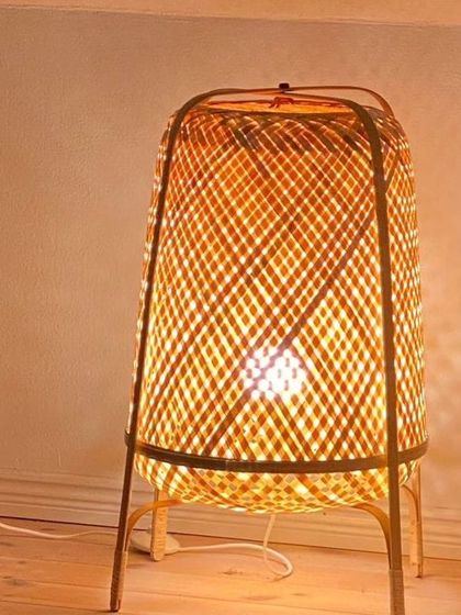 This woven bamboo table lamp provides a warm, ambient glow perfect for a bedside table or living room accent. Its sturdy frame and intricate weave showcase the versatility and beauty of handcrafted bamboo decor.