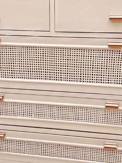 A close-up of the cane webbing and rose gold handle on our custom-made chest of drawers. This combination of natural texture and modern hardware creates a sophisticated look.