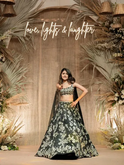 The bride posing in front of the stunning bohemian Sangeet backdrop. The neon sign "love, lights & laughter" perfectly captures the spirit of the evening.