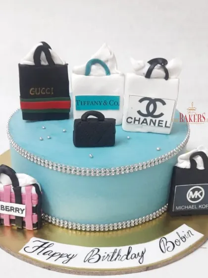 A cake for the girl who loves to shop! This design features a collection of mini shopping bags from luxury brands like Gucci, Chanel, Burberry, and Michael Kors.