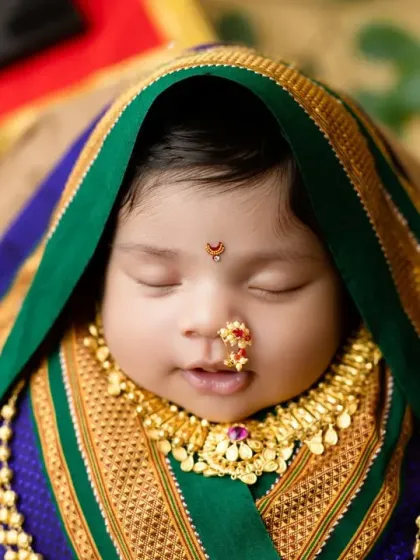 A close-up portrait focusing on the peaceful expression and traditional jewelry of our 'Marathmoli' baby.
