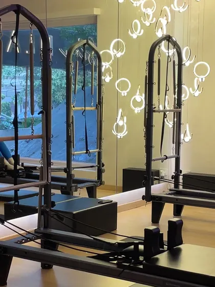 The details matter. From the modern chandeliers to the sleek black reformers, every element is chosen to create an elevated workout experience.